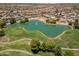Scenic aerial view of a golf course with a tranquil pond surrounded by lush fairways and mature trees at 17805 W Arizona Dr, Surprise, AZ 85374