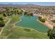 Beautiful golf course with a serene lake, mature trees, and well-maintained fairways against a clear blue sky at 17805 W Arizona Dr, Surprise, AZ 85374