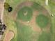 Detailed aerial view of a manicured golf course showcasing pristine greens and a lone golf cart at 17805 W Arizona Dr, Surprise, AZ 85374