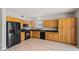 Kitchen featuring wooden cabinetry, black appliances, and wood floors at 17805 W Arizona Dr, Surprise, AZ 85374