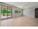 Bright living room with wood floors, ceiling fan, and sliding glass doors leading to an outdoor space at 17805 W Arizona Dr, Surprise, AZ 85374