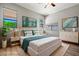 Staged bedroom with a king-sized bed, stylish decor, wood floors, and ample natural light at 17805 W Arizona Dr, Surprise, AZ 85374