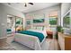 Staged bedroom featuring a mirrored closet, wood floors, and stylish decor at 17805 W Arizona Dr, Surprise, AZ 85374