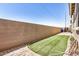 Artificial turf and pavers create a low-maintenance backyard, enclosed by a tall block wall fence at 17862 N 114Th Ln, Surprise, AZ 85378