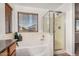 This bathroom features a soaking tub with a glass-enclosed shower, along with a large window for natural light at 17862 N 114Th Ln, Surprise, AZ 85378