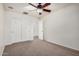 This empty bedroom features neutral colored walls, carpeting, ceiling fan, and a double door closet at 17862 N 114Th Ln, Surprise, AZ 85378