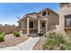 Charming home with a covered front porch, stone accents, and xeriscaped landscaping at 17862 N 114Th Ln, Surprise, AZ 85378