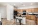Well-lit kitchen with stainless steel appliances, tan cabinetry, granite counters, an island with bar seating, and tile flooring at 17862 N 114Th Ln, Surprise, AZ 85378