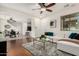 Open-concept living area with wood floors, a white sofa, and a view of the dining area and kitchen at 17862 N 114Th Ln, Surprise, AZ 85378