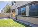 A view of the backyard with a manicured artificial lawn, covered patio, and tan exterior at 1886 E Don Carlos Ave # 136, Tempe, AZ 85281