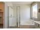 Bathroom featuring glass enclosed shower and soaking tub with a window view at 1886 E Don Carlos Ave # 136, Tempe, AZ 85281