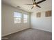 Bright bedroom featuring plush carpet, a modern ceiling fan, and two windows at 1886 E Don Carlos Ave # 136, Tempe, AZ 85281