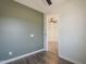 View into a bedroom with grey walls, hard surface floors, and a ceiling fan visible through the doorway at 1886 E Don Carlos Ave # 136, Tempe, AZ 85281