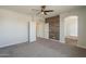 Carpeted main bedroom featuring wood accent wall, ceiling fan and ensuite bath access at 1886 E Don Carlos Ave # 136, Tempe, AZ 85281