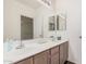 Bright bathroom featuring double sinks, wood cabinets, and large mirrors for a functional and stylish space at 205 N 74Th St # 110, Mesa, AZ 85207