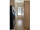 Walk-in pantry area with light wood cabinets next to black refrigerator and wood-look tile floors at 205 N 74Th St # 110, Mesa, AZ 85207