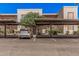 Exterior view of a parking area with covered spaces and landscaping in a multi-unit residential complex at 205 N 74Th St # 110, Mesa, AZ 85207