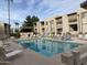 Community pool surrounded by lounge chairs, offering a relaxing space in a well-maintained complex at 205 N 74Th St # 110, Mesa, AZ 85207