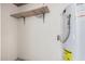 Functional utility room with a water heater, shelf, and wire basket for practical storage solutions at 205 N 74Th St # 110, Mesa, AZ 85207