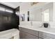 Contemporary bathroom with gray vanity, black marble tile, and decorative gold fixtures at 2421 S 65Th Dr, Phoenix, AZ 85043