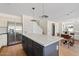 Bright kitchen features a large island with white countertop, stainless steel appliances, and opens to the dining area at 2421 S 65Th Dr, Phoenix, AZ 85043
