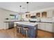 Bright kitchen featuring an island, bar stool seating, stainless steel appliances, and updated cabinetry at 2421 S 65Th Dr, Phoenix, AZ 85043
