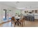 Spacious kitchen and dining area with modern island, white cabinets, stainless steel appliances and outside access at 2421 S 65Th Dr, Phoenix, AZ 85043