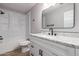 This bathroom features a framed mirror, single sink, white cabinets, a toilet, and a tub with shower at 3014 W Zachary Dr, Phoenix, AZ 85027