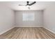 An empty bedroom with wood flooring, a ceiling fan, neutral paint, and a window with blinds at 3014 W Zachary Dr, Phoenix, AZ 85027