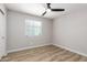 An empty bedroom with wood flooring, a ceiling fan, neutral paint, and a window with blinds at 3014 W Zachary Dr, Phoenix, AZ 85027