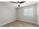 An empty bedroom with wood flooring, a ceiling fan, neutral paint, and a window with blinds at 3014 W Zachary Dr, Phoenix, AZ 85027