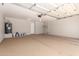 Clean, empty garage with coated floors, water heater, and a white door leading to the house at 3014 W Zachary Dr, Phoenix, AZ 85027