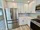 Contemporary kitchen showcasing stainless steel appliances, white cabinetry, stone backsplash and countertops, and modern hardware at 3014 W Zachary Dr, Phoenix, AZ 85027