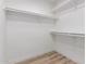A walk-in closet with white walls, wood floors, and multiple shelves for clothing storage at 3014 W Zachary Dr, Phoenix, AZ 85027