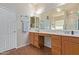 Bright bathroom featuring dual sinks, wooden cabinetry, and a large mirror at 3553 W Dancer Ln, San Tan Valley, AZ 85144