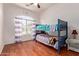 Inviting bedroom with a bunk bed, hard wood floors and a bright window at 3553 W Dancer Ln, San Tan Valley, AZ 85144