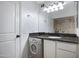 This bathroom features dark stone countertops, white cabinets and a washer/dryer unit at 3619 E Monterosa St # 202, Phoenix, AZ 85018