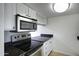 Well-lit kitchen with stainless steel microwave, oven and dark granite countertops at 3619 E Monterosa St # 202, Phoenix, AZ 85018