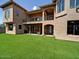 Expansive backyard of a multi-story home, featuring a covered patio and lush green artificial turf at 3804 E Camelback Rd, Phoenix, AZ 85018
