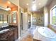 Luxurious main bathroom with a soaking tub, granite countertops, dual sinks, tile floors, and a glass shower at 3804 E Camelback Rd, Phoenix, AZ 85018