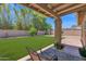 Inviting backyard with lush green lawn, covered patio, and mature trees creating a private oasis at 3919 E Larkspur Dr, Phoenix, AZ 85032