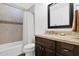Bathroom boasts a tiled shower-tub combo, a wood vanity with granite counters, and a large framed mirror at 3919 E Larkspur Dr, Phoenix, AZ 85032