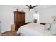 Bright bedroom with wood floors, a ceiling fan, and a large armoire for ample storage space at 3919 E Larkspur Dr, Phoenix, AZ 85032