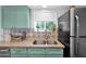 Close-up of a kitchen featuring blue cabinets, granite countertops, and a tile backsplash at 3919 E Larkspur Dr, Phoenix, AZ 85032