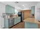Charming kitchen featuring blue cabinets, granite countertops, a tile backsplash, and stainless steel appliances at 3919 E Larkspur Dr, Phoenix, AZ 85032