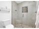 Bright bathroom shower featuring travertine tile, a pebble floor, and a frameless glass enclosure at 3919 E Larkspur Dr, Phoenix, AZ 85032
