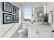 Charming bathroom with patterned tile flooring, a white vanity, a modern faucet, and a large window at 4131 E Roma Ave, Phoenix, AZ 85018
