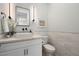 Stylish half-bath featuring modern fixtures, white vanity, and decorative wainscoting at 4131 E Roma Ave, Phoenix, AZ 85018