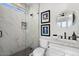 Modern bathroom featuring a sleek vanity, a round mirror, and a shower with patterned tile and glass enclosure at 4131 E Roma Ave, Phoenix, AZ 85018