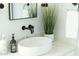 Close-up of an elegant bathroom featuring a white vessel sink, modern faucet, and decorative accents at 4131 E Roma Ave, Phoenix, AZ 85018
